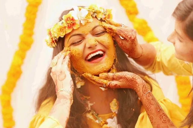indian haldi girl smiling marigolds
